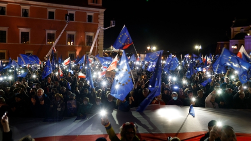 Participants wave EU flags over a large Polish flag as they take part in a pro-EU demonstration