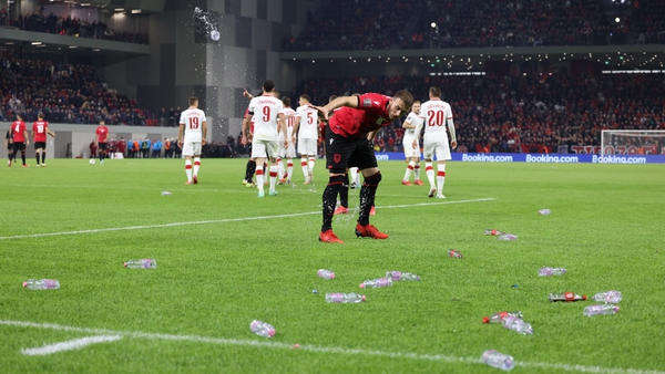 The match is suspended because of fans throwing objects onto the pitch