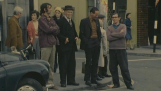Group of men chatting at street corner, Tuam, County Galway (1976)