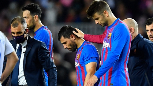 Gerard Pique (R) consoles Sergio Aguero as he leaves the field with an injury
