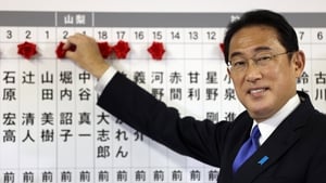 Liberal Democratic Party leader Fumio Kishida puts rosettes by successful general election candidates' names on a board at party headquarters