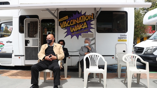 People wait at the vaccination waka, or campervan on in Kawakawa, New Zealand