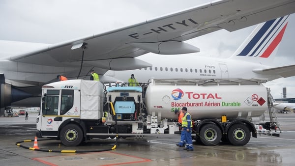 Staff members refuel an Airbus A350-900, the first Air France jet long-haul aircraft fueled with sustainable aviation fuel