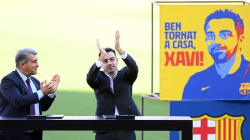 Xavi (R) applauds fans as he stands next to club president Joan Laporta