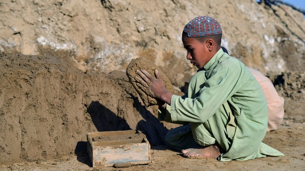 A child makes clay bricks at a kiln in Kandahar