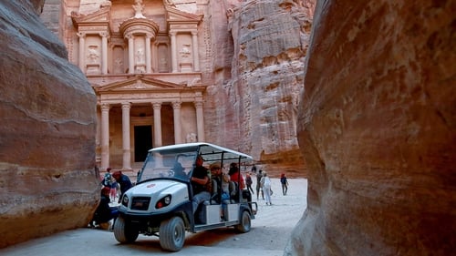 Tourists in an electric cart during their trip to Jordan's ancient city of Petra