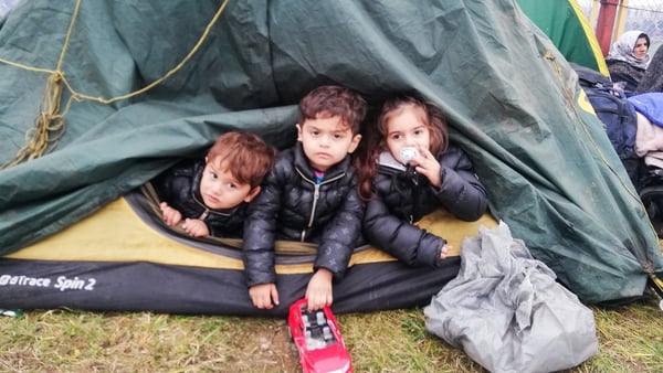 Three young children are pictured in a tent the Bruzgi Kuznica crossing point on the Belarusian-Polish border