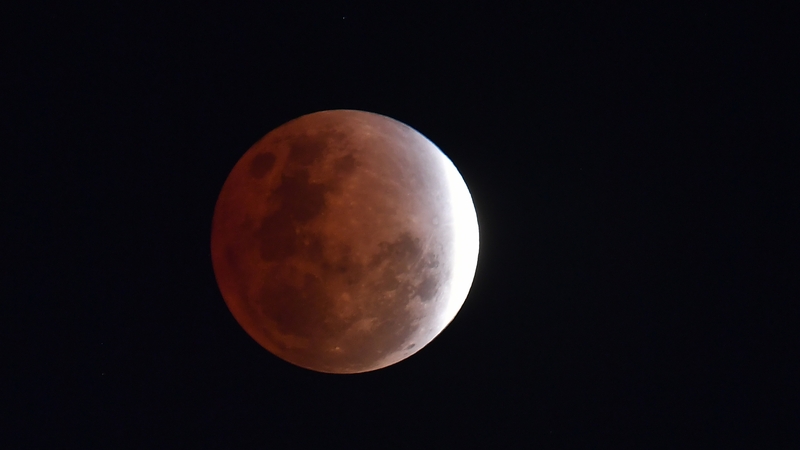 The Moon is seen as the Earth's shadow covers the moon during a partial lunar eclipse over Brisbane, Australia