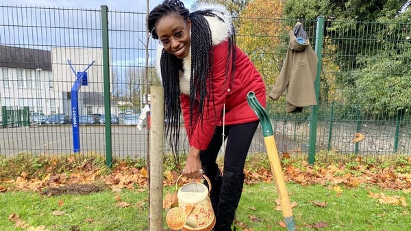 Amanda Nyoni, who is originally from Zimbabwe, plants one of the first trees in the 'Putting Down Roots' project