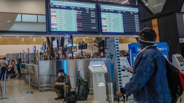 A passenger inspects a flight notice board displaying cancelled flights at OR Tambo International Airport in Johannesburg