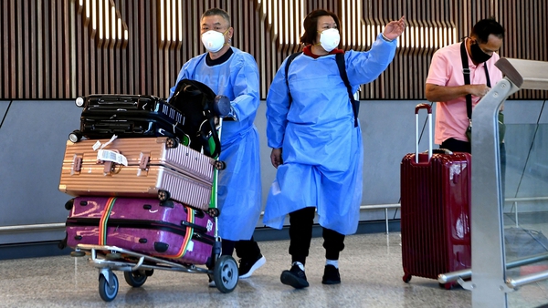 International travellers wearing PPE arrive at Melbourne's Tullamarine Airport