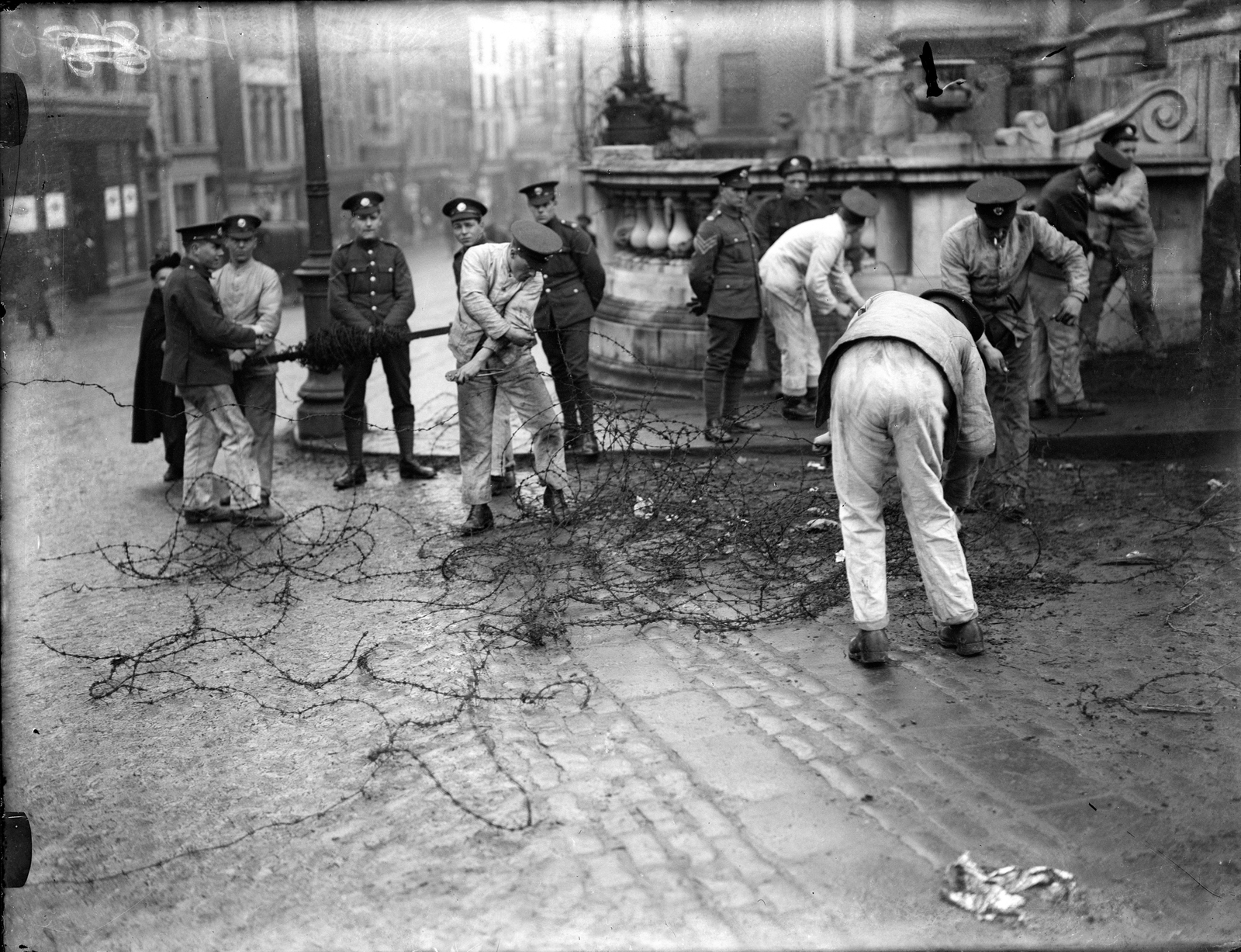 Image - British troops in work fatigues dismantle the barriers and bunkers around Dublin Castle. Credit: Cashman Collection