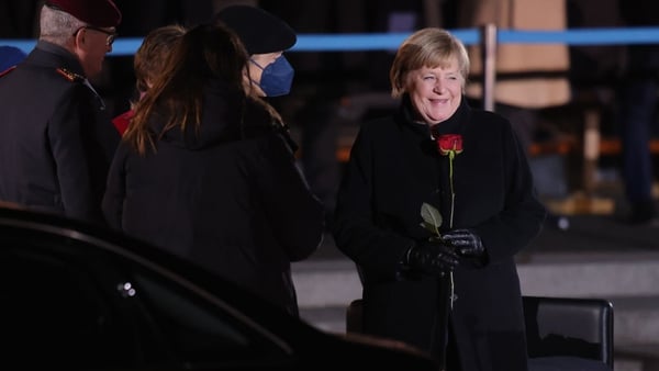 Angela Merkel holds a red rose at the conclusion of her military tattoo ceremony
