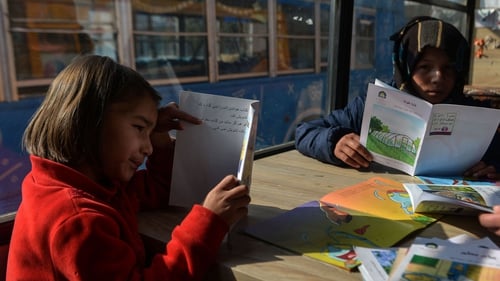 Children reading inside a mobile library that opened its doors for the first time since the Taliban's return to power