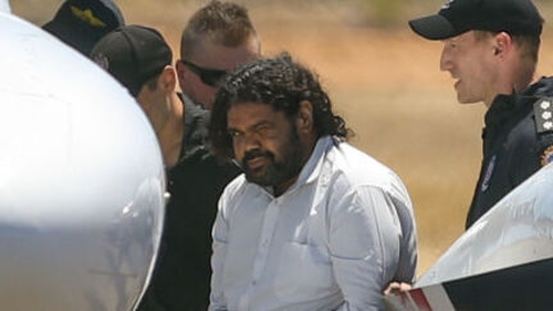 Terence Darrell Kelly boards a plane after being taken into custody (File photo)