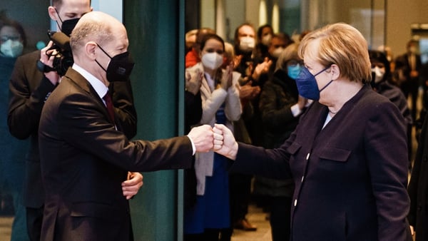 Olaf Scholz fist pumps Angela Merkel as she leaves the Chancellery in Berlin