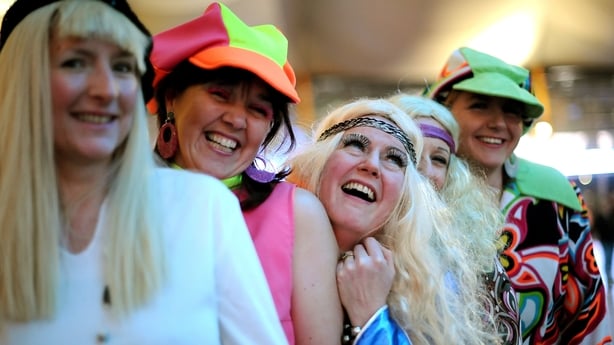 Fans of the film "Mamma Mia" pose in costumes for pictures as they arrive for a special screening of the film at at the O2 aren