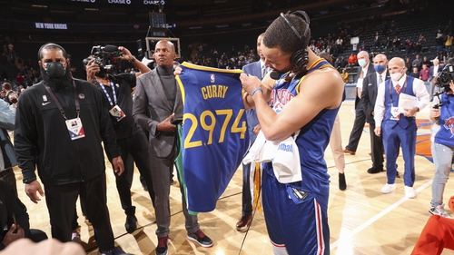 Steph Curry holds up a jersey after passing Ray Allen's mark of 2,973 three-pointers