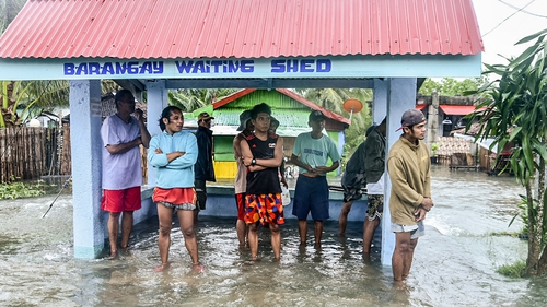 Residents stand in a flooded area in the coastal town of Guiuan, central Philippines' Eastern Samar province