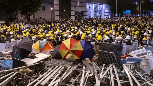 Crowds behind barricades before the dramatic storming of the city's legislature in July 2019