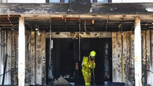 Firefighters assess the damage to the portico of the building in Canberra
