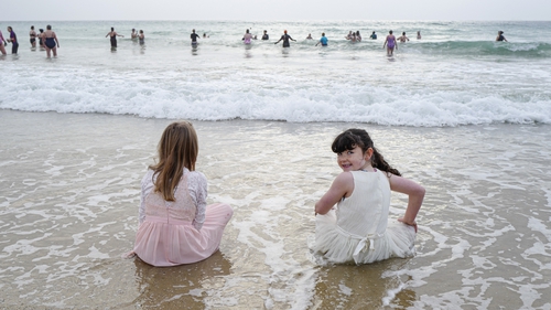 Young members of the She Swims Falmouth group in Cornwall enter the sea for a New Year's Eve swim at Gyllyngvase Beach