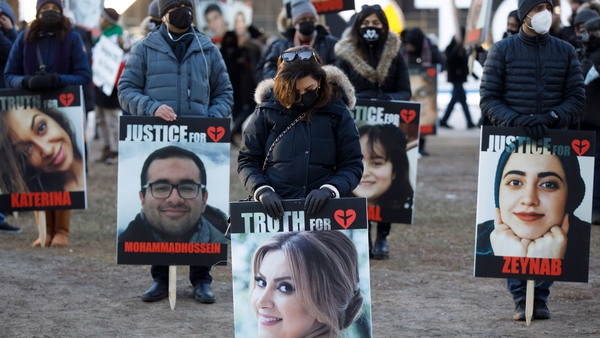 People hold signs with images of the victims of the downed Ukraine plane, in a march last year in Toronto, Ontario