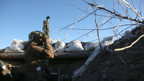 A Ukrainian Military Forces servicemen watches through spyglass on a trench on the frontline with Russia-backed separatists near to Avdiivka, southeastern Ukraine, January 8