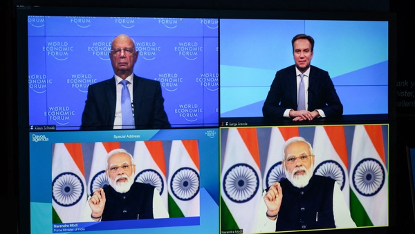Founder and Executive chairman of the WEF Klaus Schwab and WEF president Borge Brende listen to India's Prime Minister Narendra Modi