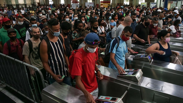 People move through the turnstiles at the Bras subway station in Sao Paulo, Brazil