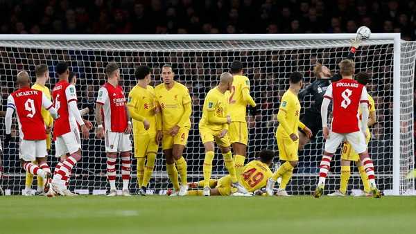 Liverpool goalkeeper Caoimhin Kelleher gets a finger tip to push Alexandre Lacazette's free-kick onto the crossbar
