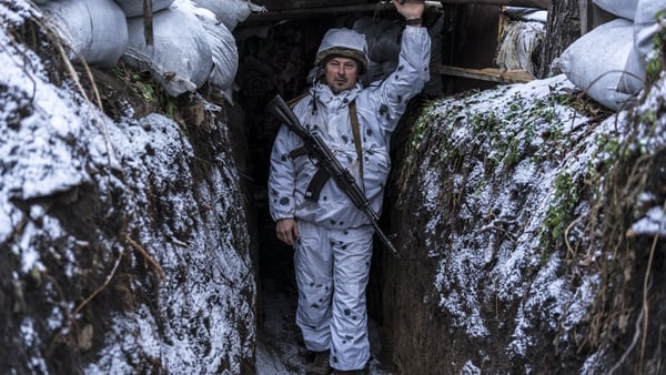 A Ukrainian soldier poses for a photo in a trench on the front line in Pisky, Ukraine
