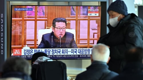 People in Seoul watch a television screen showing a news broadcast with file footage of Kim Jong-un