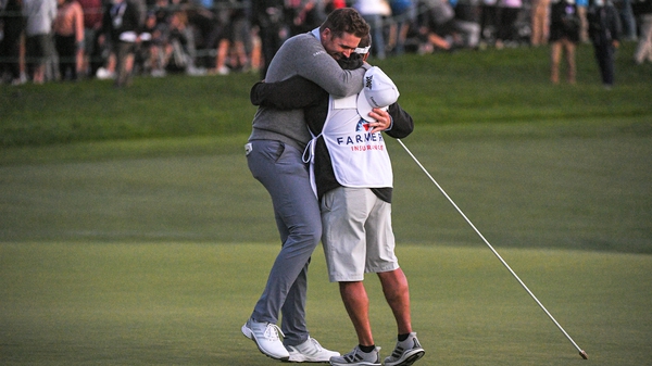 Luke List hugs his caddie on the 18th green after winning the play-off hole during the final round of the Farmers Insurance Open