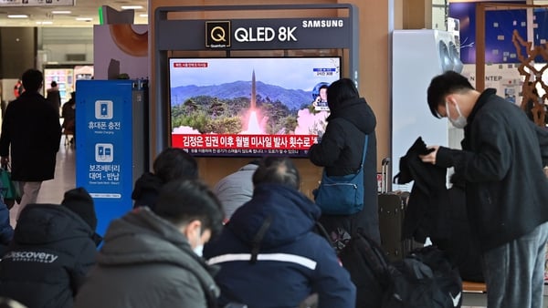 People watch a television screen showing a news broadcast with file footage of a North Korean missile test, at a railway station in Seoul this morning