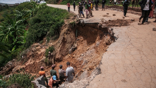 Residents at a partially collapsed road following the passage of cyclone Batsirai