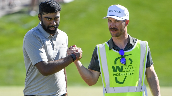Sahith Theegala is congratulated by his caddie Carl Smith at the 18th hole.