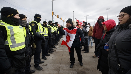 Protesters confront police as they try to clear the Ambassador Bridge