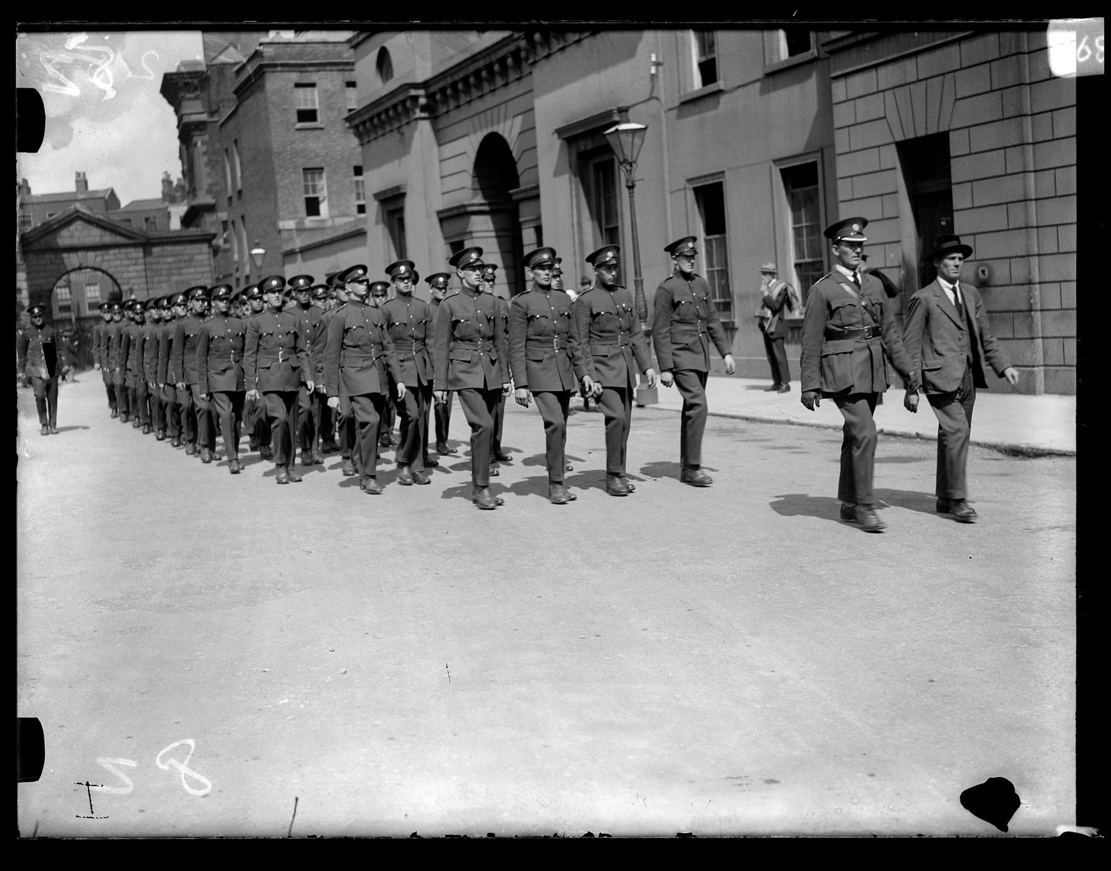 Image - The Civic Guard march into Dublin Castle, led by Commissioner Michael Staines. He is in civilian clothes; this was his last act before resignation. Image: Cashman Collection, RTÉ Archive