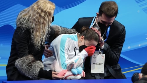 Kamila Valiyeva is consoled by her coaches Eteri Tutberidze and Daniil Gleikhengauz