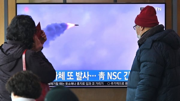People watch a television screen showing a news broadcast with file footage of a North Korean missile test, at a railway station in Seoul