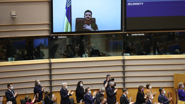Ukrainian President Volodymyr Zelensky (on screen) is applauded at the European Parliament