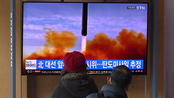 People in Seoul, South Korea watch a television screen showing a news broadcast with file footage of a North Korean missile test