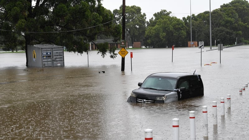 A car sits submerged on a road beside the Georges River in the suburb of Milperra in Sydney