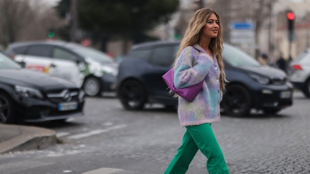 Stylist Emili Sindlev seen wearing a batik cardigan, green jeans, pink Loewe bag and purple heels on March 04, 2022 in Paris, France. Photo: Getty.