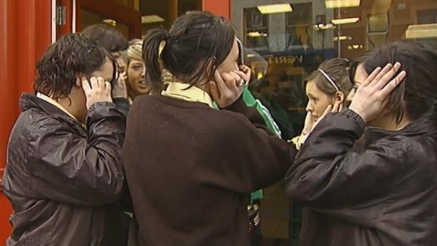 Teenagers block their ears from the mosquito device (2007)