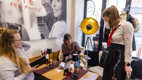 A woman shows her Covid vaccine pass in a restaurant in Innsbruck, Austria