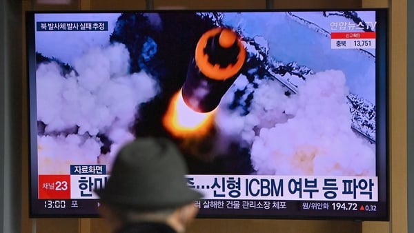People at a train station in Seoul watch a news broadcast with file footage of a North Korean missile test