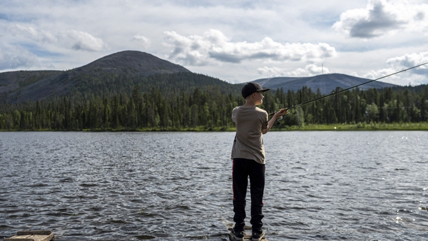A boy fishes on the Kesanki Lake in Akaslompolo, Kolari in Lapland, Northern Finland
