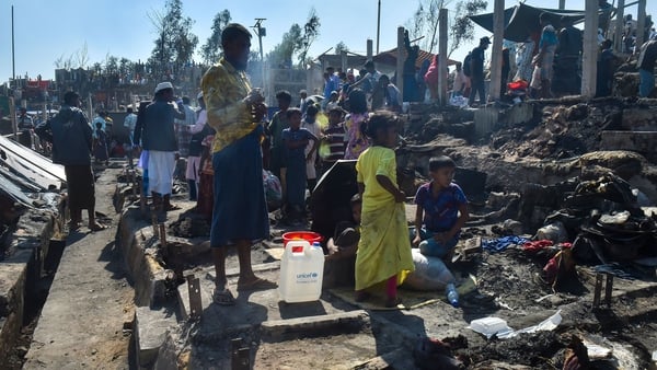 People gather on the ground after a fire gutted parts of a Rohingya refugee camp in Ukhia, Bangladesh, in January